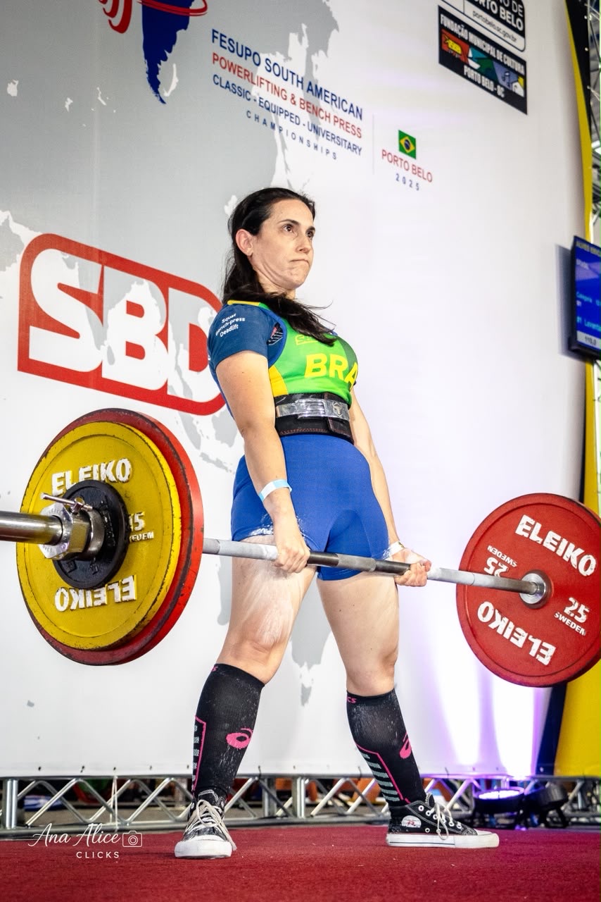 Érica Duque executando o levantamento terra em competição, com o uniforme da seleção brasileira