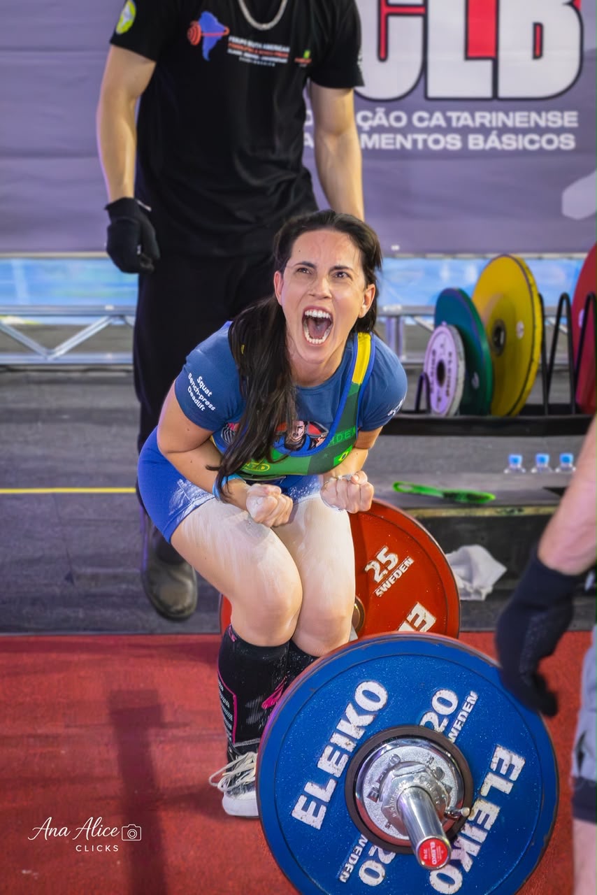 Érica Duque comemorando após uma tentativa válida em competição de powerlifting