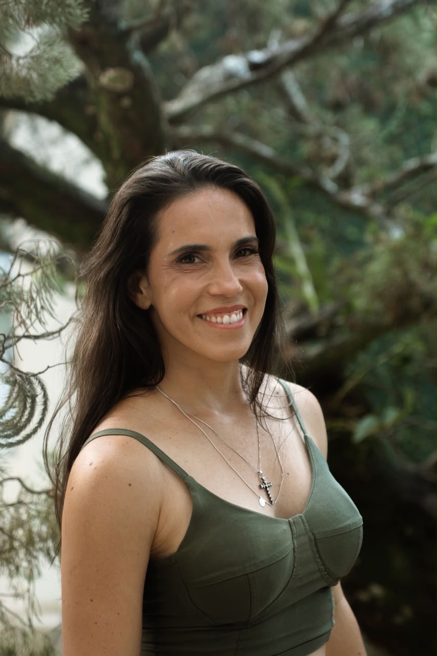 Érica Duque ao ar livre, entre árvores